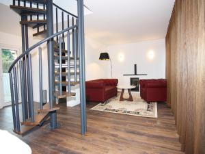 a living room with a staircase and a red couch at Chalet in Wendorf, cleaning included in Wendorf