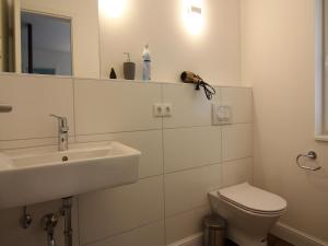 a white bathroom with a sink and a toilet at Chalet in Wendorf, cleaning included in Wendorf