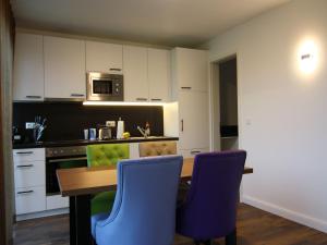 a kitchen with a wooden table and blue chairs at Chalet in Wendorf, cleaning included in Wendorf