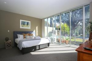 a bedroom with a bed and a large window at The Glass Pinnacle in Bright