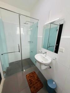 a bathroom with a glass shower and a sink at Airport S4 Apartment in Negombo