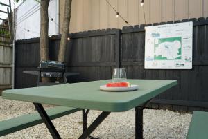 a green picnic table with a glass of watermelon on it at Cozy 1BR Tiny Home near Downtown and NB Rivers in New Braunfels