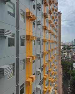 un bâtiment avec des balcons jaunes sur son côté dans l'établissement Mazal Residence, à Manille