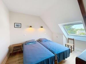 a bedroom with a bed with blue sheets and a window at Appartement en bord de mer, 1 chambre, 4 couchages, parking privé - FR-1-361-570 in Jullouville-les-Pins