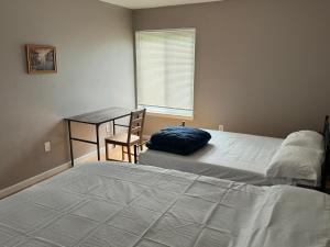 a bedroom with two beds and a desk and a window at Near To CCBC ESSEX Private Room 202 in Parkville