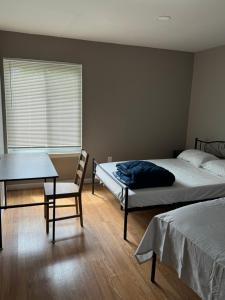 a bedroom with two beds and a table and a chair at Near To CCBC ESSEX Private Room 202 in Parkville