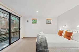 a bedroom with a white bed and a large window at Elevated Elegance in Fernhill in Queenstown