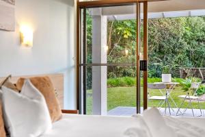 a bedroom with a bed and a view of a patio at Nautilus Resort Apartment 162 Solitary Islands Way 8 in Sapphire Beach +19 photos