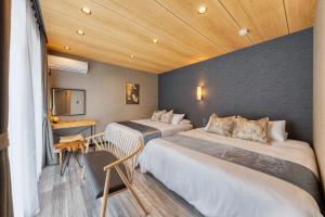 a hotel room with two beds and a television at Liendepremie讃 貸切の宿 金刀比羅宮参道まで徒歩5分 敷地内駐車場5台 in Kotohira