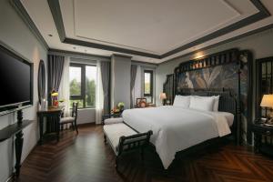 a bedroom with a large bed and a television at THE LEGEND HANOI Hotel in Hanoi