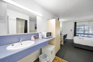 a bathroom with a sink and a bed at Oscar Motel in Bundaberg +76 photos