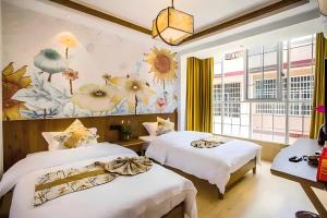 張家界市にあるOne house Art Hotelの花が飾られた壁の客室内のベッド2台