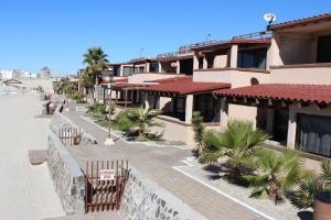 a view of a street with buildings and palm trees at Las Gaviotas 402 Mid-century Ocean View Apartment in Puerto Peñasco