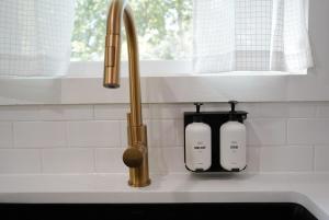 eine Küchenspüle mit zwei Seifenspendern neben einer Küchenspüle in der Unterkunft Oak and Agave House - Downtown New Braunfels Retreat in New Braunfels + 56 Fotos