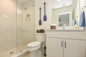 a white bathroom with a toilet and a shower at The White House on Flagler Beach - Unit 23 in Flagler Beach +25 photos