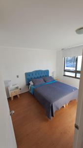 a bedroom with a blue bed and a window at Aníbal Pinto Apartment 2D 2B in Concepción