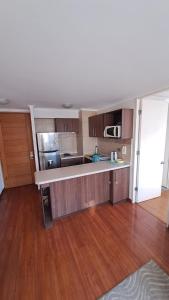 a large kitchen with wooden floors and a counter top at Aníbal Pinto Apartment 2D 2B in Concepción
