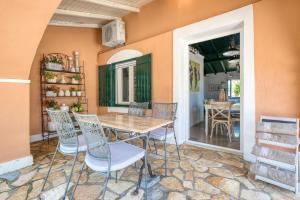 a dining room with a table and chairs at Elissavet by Vintage Travel in Ermones