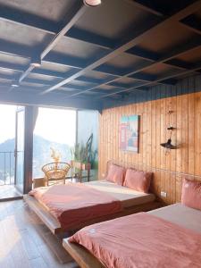 a bedroom with two beds and a large window at Lego Homestay Tam Đảo Venuestay in Vĩnh Phúc
