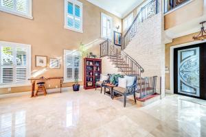 フォート・ローダーデールにある5BR Luxury Mins to Las Olas, Shops and Beachのリビングルーム(階段、テーブル、椅子付)