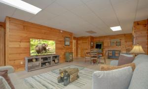 a living room with a bear on the tv at Homestead Hideaway in Sevierville