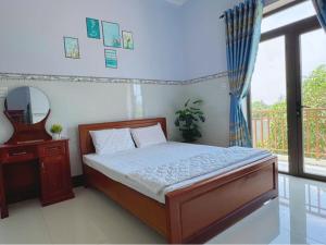 a bedroom with a bed and a mirror and a window at Khách Sạn Toàn Uy - Đảo Phú Quý in Cu Lao Thu