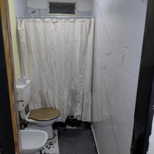 a bathroom with a toilet and a shower curtain at hospedaje El Colibrí in La Unión