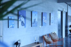 a white wall with pictures on it with two chairs at 緩慢大鵬灣 in Donggang
