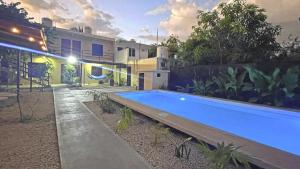 ein großer blauer Swimmingpool vor einem Haus in der Unterkunft Beryllos Bacalar in Bacalar