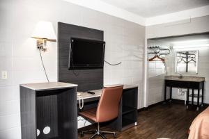 a hotel room with a desk with a computer and a television at Budget Inn in Carthage +28 photos