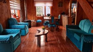 a living room with blue couches and a table at Coñaripe Kuyen Mapu Cabañas in Coñaripe