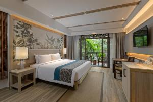 ein Schlafzimmer mit einem Kingsize-Bett und einem Schreibtisch in der Unterkunft Khaolak Merlin Resort in Khao Lak + 37 Fotos
