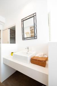 a white bathroom with a sink and a mirror at WITH SEA Nakama in Onna