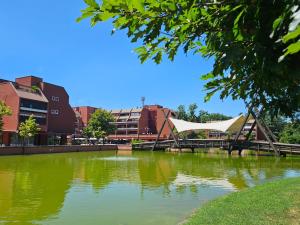 a bridge over a river with buildings in the background at LuMI Apartment in Basiglio