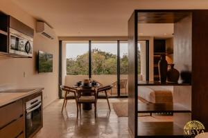 a kitchen with a table and a dining room at Peregrina Tulum 317 1-Bedroom Condo in Tulum
