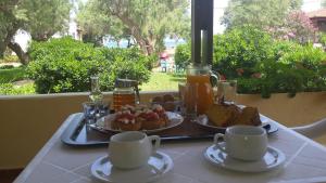 a table with two plates of food and cups on it at Rooms Leonidas in Kissamos