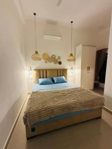 a bedroom with a large bed with two blue pillows at Bamboo Breeze Jaffna in Jaffna +13 photos