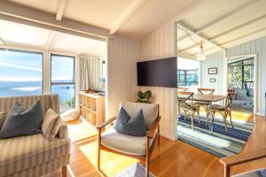 una sala de estar con un sofá y una mesa en Clifftop Sanctuary - Stay Waiheke, en Oneroa