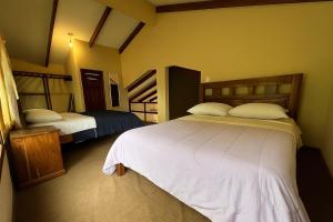 a bedroom with two beds and two bunk beds at Cabaña Las Retamas in Samaipata