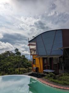 ein Haus mit einem Swimmingpool vor einem Gebäude in der Unterkunft Alojamiento el Mirador in Tapantí