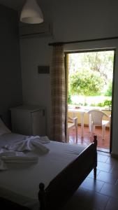 a bedroom with a bed and a sliding glass door at Rooms Leonidas in Kissamos