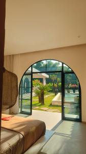 ロビナにあるVilla Cactus is far from home but like your home Villa Cactus 3 BR isn't just a tropical villa in the heart of a coconut grove it's a feeling Next door Villa Sungai also offers 2 BR and 1 Bungalow Ability to accommodate 12 peopleのベッドルーム(大きな窓、ベッド付)