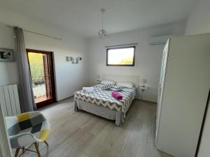 a bedroom with a bed and a window at Casa Le Cicale in Porto Istana
