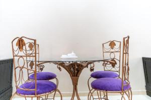 a dining room with purple chairs and a glass table at Peaceful Marrakech Villa 4 Bedrooms Private Pool in Marrakech