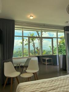 a bedroom with a table and chairs and a large window at Sky Pavilion in Kandy