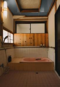 a large bath tub in a bathroom with a window at THE Aramaki 日本の魅力と伝統が詰まった築200年の古民家 1日1組限定貸切 in Ō-naka +42 photos
