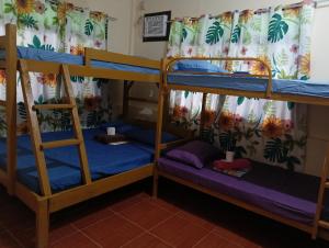a room with two bunk beds with blue sheets at CABUGAO Dormitory in El Nido