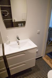 a bathroom with a white sink and a mirror at Uus Street 34 Apartment in Kuressaare