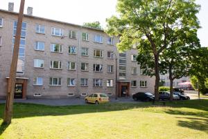 un gran edificio de ladrillo con un coche aparcado delante de él en Uus Street 34 Apartment, en Kuressaare