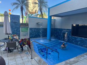 a person in a swimming pool with a water fountain at Serra Park in Rio Quente